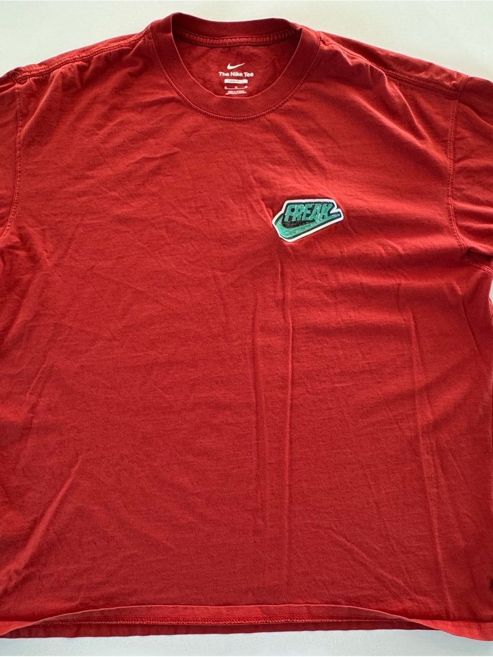 Nike Greek Freak Men’s Red Short Sleeve Tee with Green Logo Patch